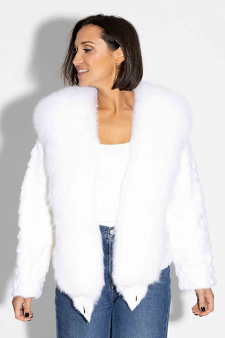 woman wearing a white sheared sectioned mink fur jacket with white fox fur tux against a white backdrop