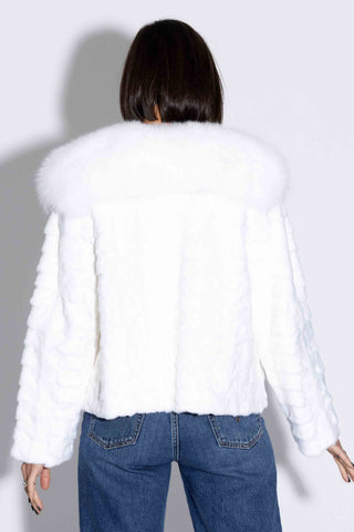 back of woman wearing a white sheared sectioned mink fur jacket with white fox fur tux against a white backdrop