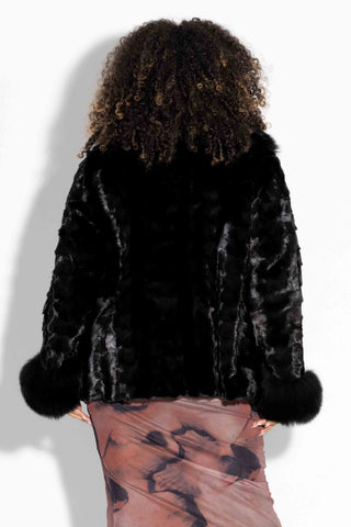 back of ranch sectioned mink fur jacket with black fox fur trim against a white backdrop