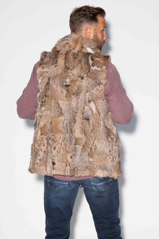 back of man wearing a sectioned bobcat fur vest with shawl collar against a white backdrop