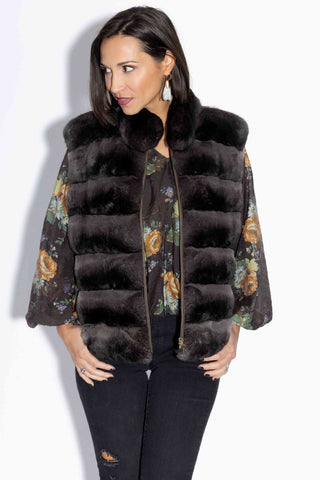 woman wearing a charcoal chinchilla fur vest with mink fur back, with her thumbs in pockets, against a white backdrop