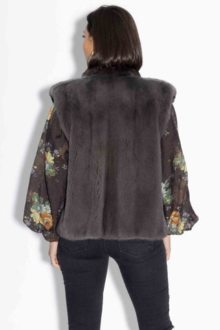 back of woman wearing a charcoal chinchilla fur vest with mink fur back against a white backdrop