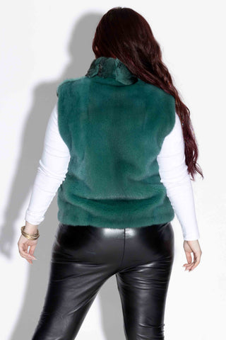 back of woman wearing an emerald chinchilla fur vest with mink fur back against a white backdrop
