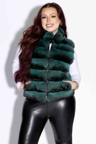 smiling woman wearing an emerald chinchilla fur vest with mink fur back against a white backdrop