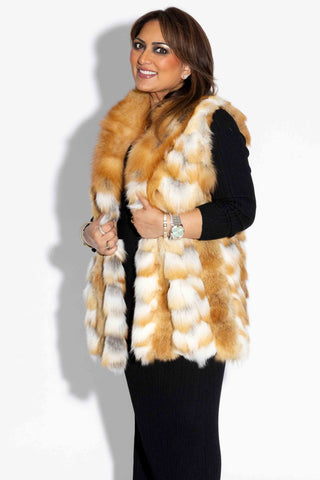 side profile of a smiling woman wearing a natural red sectioned fox fur vest with shawl collar against a white backdrop