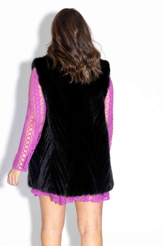 back of woman wearing a ranch chevron sectioned mink fur vest with shawl collar against a white backdrop