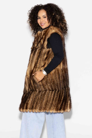 side profile of woman wearing a whisky chevron sectioned mink fur vest against a white backdrop
