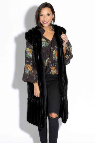 woman wearing a long ranch chevron sectioned mink fur vest with leather inserts against a white backdrop
