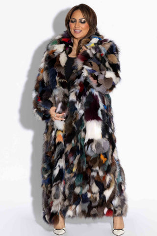 woman wearing a full length multicolor sectioned fox fur coat against a white backdrop