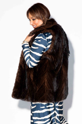side profile of woman wearing a mahogany Chevron Sectioned Mink Fur Tails Vest with Shawl Collar