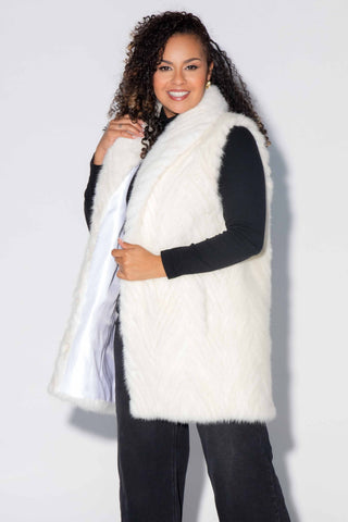 smiling woman wearing a pearl Chevron Sectioned Mink Fur Tails Vest with Shawl Collar with a little bit of the white lining showing inside