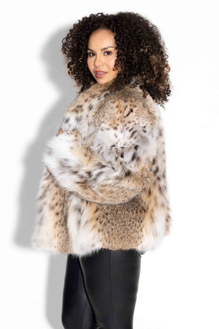 side profile of woman wearing a natural bobcat fur bolero jacket with shawl collar against a white backdrop