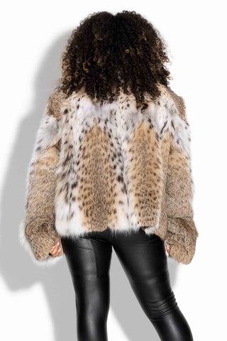 back of woman wearing a natural bobcat fur bolero jacket with shawl collar against a white backdrop
