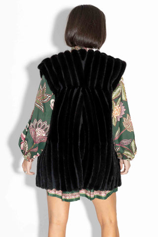 back of woman wearing a ranch chevron sectioned mink fur vest against a white backdrop