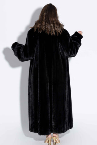 back of woman wearing a ranch mink fur coat against a white backdrop