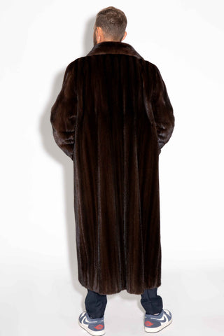 back of man wearing a custom-made men's mahogany full length mink fur coat against a white backdrop