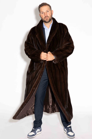 man wearing a men's custom-made full length mink fur coat against a white backdrop