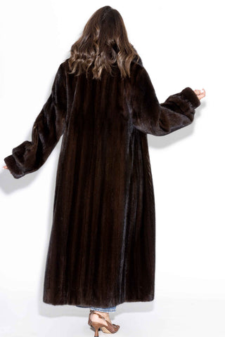 back of woman wearing a full length mahogany mink fur coat with fox fur tux against a white backdrop