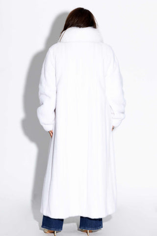 back of woman wearing a white full length mink fur coat with fox fur tux against a white backdrop