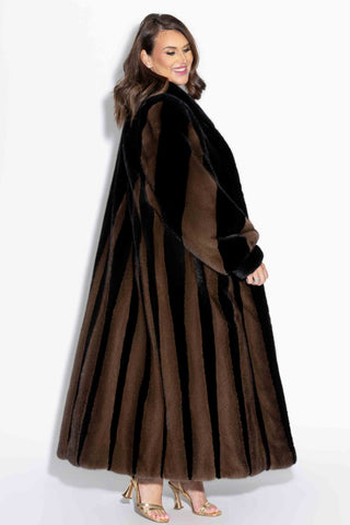 side profile of a woman wearing a ranch and demi buff two-toned full length mink fur coat against a white backdrop