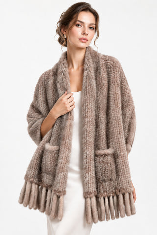 woman wearing a pastel knitted mink fur shawl against a white backdrop