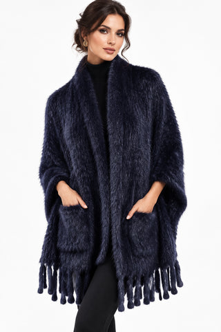 woman wearing a navy knitted mink fur shawl against a white backdrop