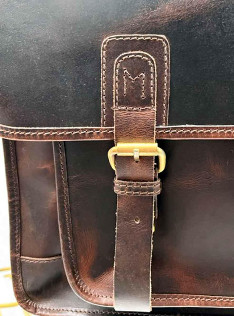 detail of buckles on dark brown leather messenger bag/briecase